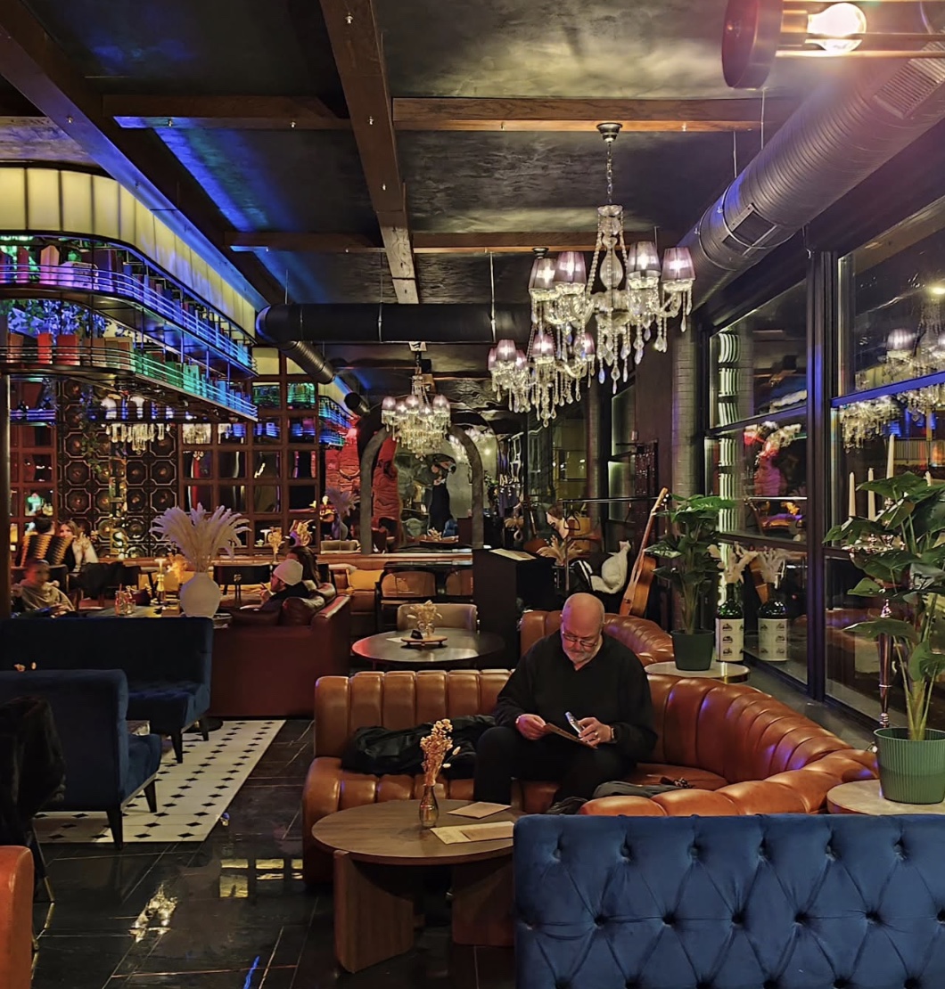 Warme Lounge-Atmosphäre bei Charlie’s mit Kronleuchtern, Leder- und Samtsofas